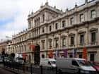 Vista lateral del edificio Burlington House desde la calle Piccadilly con vehículos en primer plano