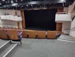 Interior del auditorio con butacas naranjas y escenario