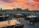 Terraza con vistas al atardecer y mesas dispuestas para cena
