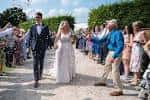 Boda al aire libre en el jardín amurallado con invitados celebrando