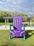 Silla gigante decorativa de estilo Adirondack en el césped del parque