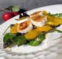 Ensalada elegante con queso grillado y frutas de temporada