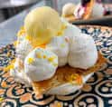 Postre artesanal con helado, crema y decoración cítrica