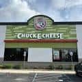 Vista frontal del establecimiento de Chuck E. Cheese con letrero verde y logo