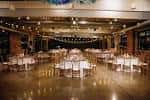 Salón principal iluminado con luces colgantes y mesas dispuestas para recepción