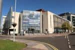 Vista exterior del Public Record Office of Northern Ireland con fachada moderna de cristal y piedra