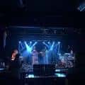 Escenario del venue durante un concierto con iluminación azul y banda en vivo