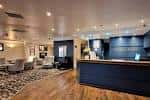 Recepción moderna del hotel con mobiliario elegante y suelo de madera
