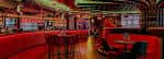 Interior del Carousel Bar con iluminación roja y zona de juegos