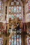 Ceremonia de boda en el interior del Leeds Minster con vitrales y reflejos en el suelo pulido