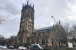 Vista exterior del Leeds Minster mostrando su torre gótica y fachada histórica