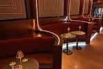 Área de lounge con sofás rojos y mesas en el interior del teatro