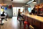 Área interior con barra y mesas, ambiente acogedor para eventos