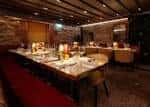 Sala de eventos privada con mesa larga decorada y ambiente cálido