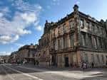Vista exterior del edificio de la Biblioteca Central de Edimburgo con arquitectura clásica y cielo azul