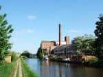 Vista panorámica del canal con edificios industriales históricos y embarcaciones amarradas