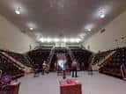 Salón de eventos con gradas laterales y espacio central listo para ceremonia o reunión