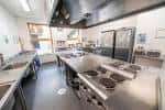 Cocina profesional equipada con encimeras de acero inoxidable y campana extractora