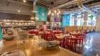 Sala de eventos con mesas rojas y decoración industrial