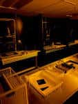 Interior oscuro del estudio fotográfico con mesas de trabajo e iluminación cálida