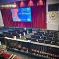Interior del auditorio con escenario y pantalla de proyección