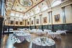 Salón de eventos decorado con mesas redondas y mantelería blanca