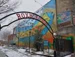 Entrada del Roxborough Pocket Park con arco decorativo y mural colorido en invierno