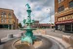 Fuente histórica en Fountain Square con edificios de ladrillo al fondo