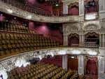 Interior del auditorio del Lyceum Theatre con balcones ornamentados, butacas rojas y escenario iluminado