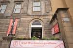 Entrada principal del Filmhouse con letreros rojos y cartel promocional en la acera