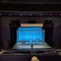 Interior del auditorio con escenario y cortina azul