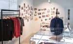 Espacio interior del museo con exhibición de ropa y fotografías en las paredes