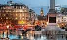 Trafalgar Square al atardecer con iluminación urbana y el obelisco iluminado