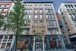 Fachada de un edificio comercial en Penn Avenue con árboles y peatones