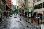Penn Avenue bajo la lluvia con personas caminando y tiendas a ambos lados