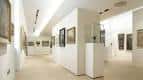 Interior de la galería con salas blancas y obras expuestas