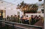 Terraza de Greenwood Brewing con clientes y decoración festiva