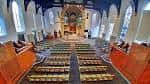 Vista panorámica del interior con altar central, vitrales y asientos dispuestos en hileras