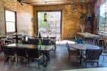 Interior del Bluewood Brewing con mesas y sillas en un espacio de ladrillo