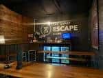 Interior del área de recepción con el logotipo de The Great Escape Game en la pared