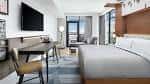 Habitación moderna con cama king-size, escritorio y vista a la ciudad