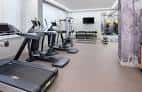 Gimnasio equipado con máquinas de cardio y zona de entrenamiento