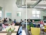 Espacio de coworking y eventos con personas trabajando en mesas compartidas