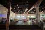 Vista general del salón principal con estructura industrial, mesas y sillas dispuestas para eventos