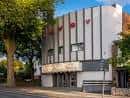 Vista exterior diurna del Savoy Cinema en Nottingham con fachada moderna y árboles alrededor