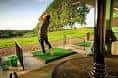 Persona practicando swing en el driving range del club