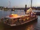 Barco decorado iluminado en el Támesis cerca de Temple Pier, ideal para eventos