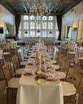Sala de eventos preparada para una boda con mesas decoradas y candelabros