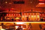 Vista del bar con mesas y sillas bajo luz cálida