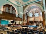 Interior de la iglesia con órgano y bancos dispuestos para eventos
